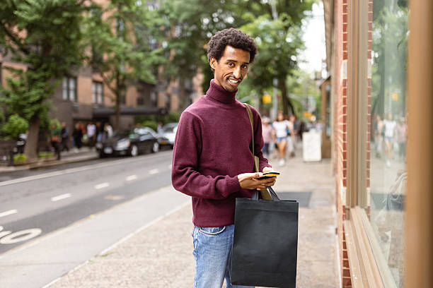 istock Street Shopper with Bag Using Smartphone 2221917395