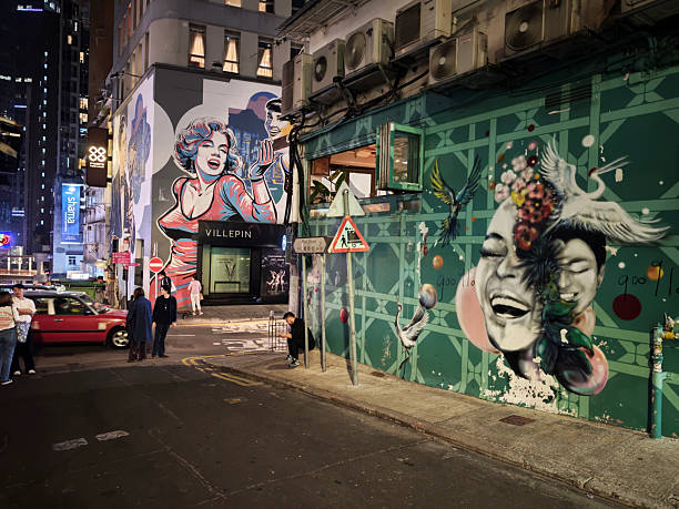 People on a street surrounded by murals in Soho, a popular nightlife area in Hong Kong.
