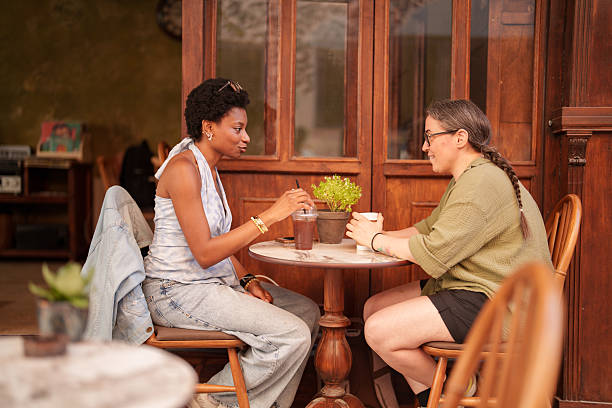 istock Two Female Friends Enjoying Coffee and Conversation at Sidewalk Cafe 2221920968