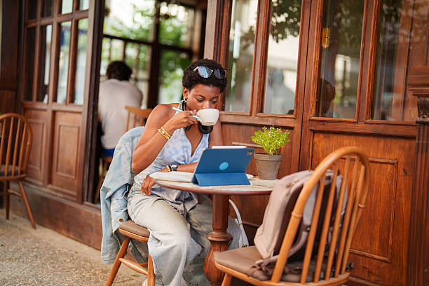 istock Young Woman Studying and Using Digital Tablet at Sidewalk Cafe 2221921232