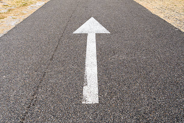 istock arrow straight ahead on asphalt road 2221921666