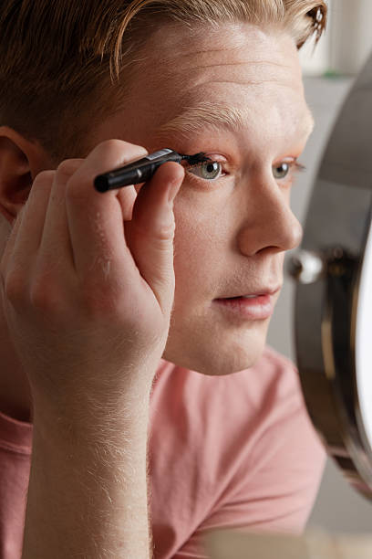 istock Man Applying Eyeliner in Front of Mirror 2221925174