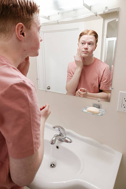 istock A Vertical Medium shot of a Man Washing Face at Bathroom Sink 2221927057