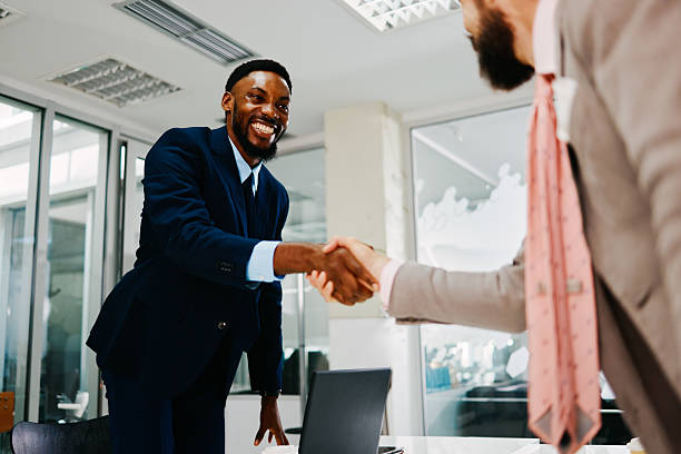 istock Two businessmen shaking hands after successful meeting in modern office 2221927083