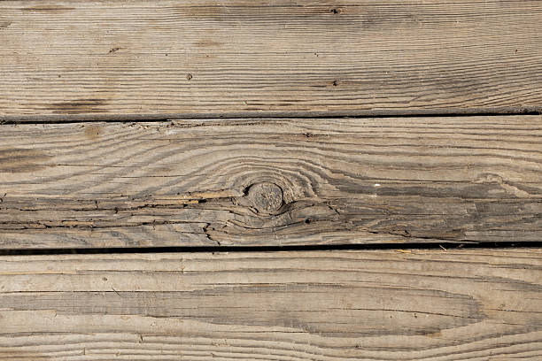 Wooden planks with a natural texture. The surface shows knots and grain patterns, creating an abstract background suitable for various design projects.