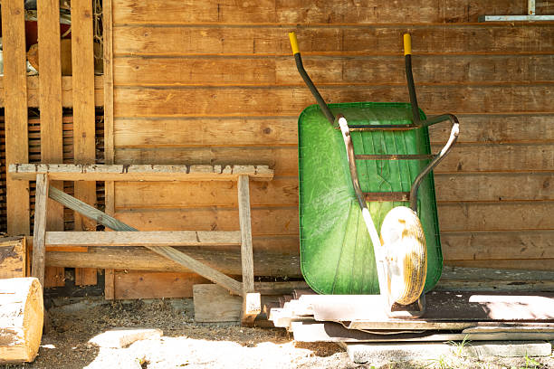 Old wooden shed with green wheelbarrow