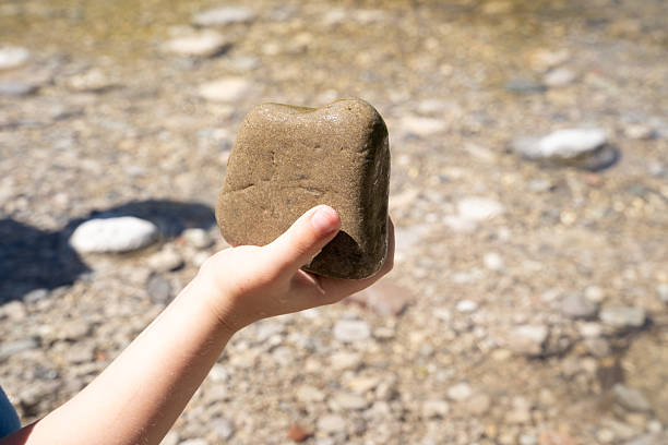 istock Child’s hand with a river rock 2221929688