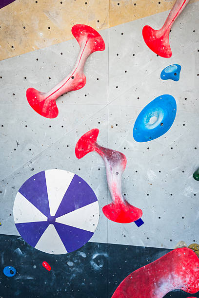 Close-up of a blue climbing wall with beige holds.