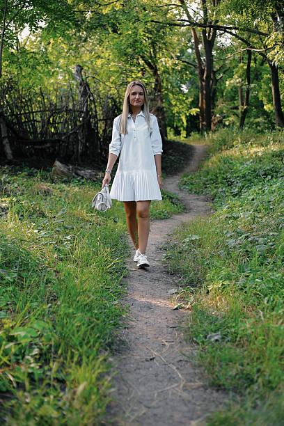 Young woman walking on a path in a forest enjoying nature
