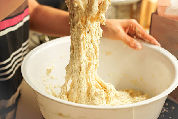 Young woman kneading dough to make bread