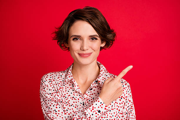 istock Photo of charming satisfied lady indicate finger empty space look camera isolated on bright red color background 2221937649