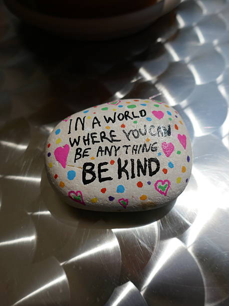 istock Shiny metal patterned surface with be kind kindness rock and sun reflection vertical photo 2221938097