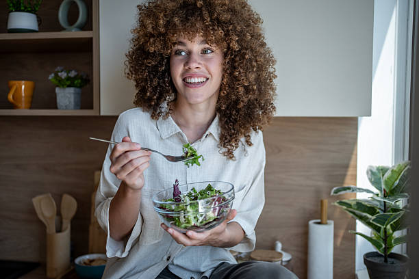 istock Young woman enjoying fresh salad in modern kitchen 2221938931