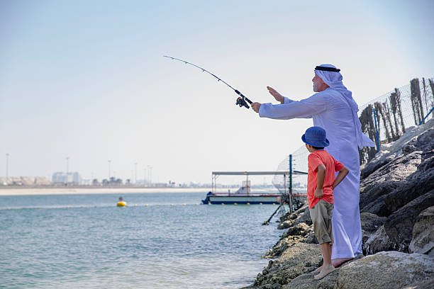 istock Arab grandfather and little boy having fun at beach 2221946871