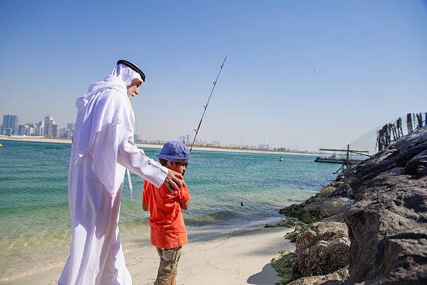istock Arab grandfather and little boy having fun at beach 2221946883