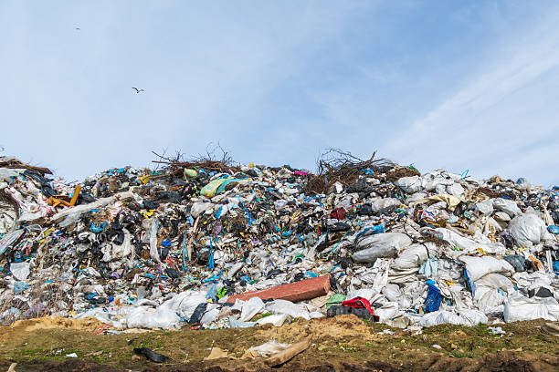 A massive landfill filled with plastic, fabric, paper, and mixed waste, highlighting pollution, environmental hazards, and the urgent need for recycling solutions