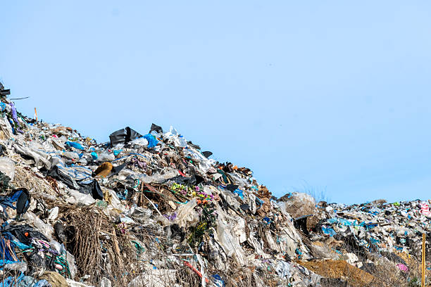 istock Vast Landfill Overflows with Piles of Discarded Waste Material Under Clear Blue Sky 2221952482