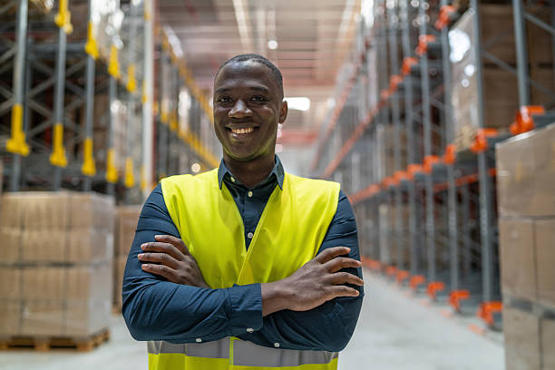istock Confident warehouse worker smiling with arms crossed 2221966159