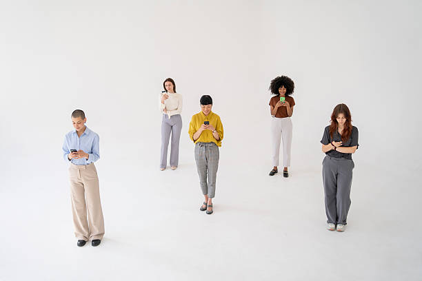 istock Five young women using their mobile phones on white background 2221966332