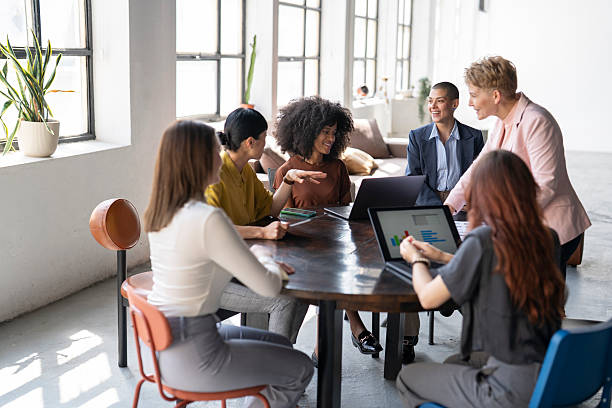 Diverse businesswomen collaborating on project in modern office