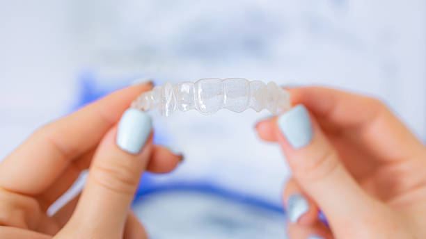 istock Close-up of hands holding a clear aligner for orthodontic teeth correction 2221966428