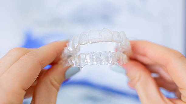 istock Close-up of clear orthodontic aligners held in hands for teeth correction 2221966434