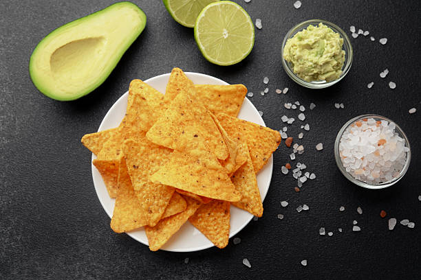 istock Nacho chips with avocado, lime, salt and guacamole on black background 2221966950
