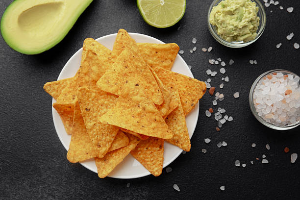 istock Nacho chips with avocado, lime, salt and guacamole on black background 2221966951