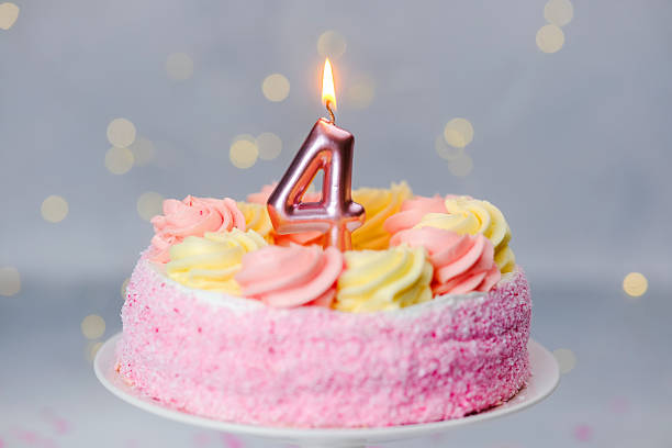 Pink frosted birthday cake with one candle for the 4th birthday