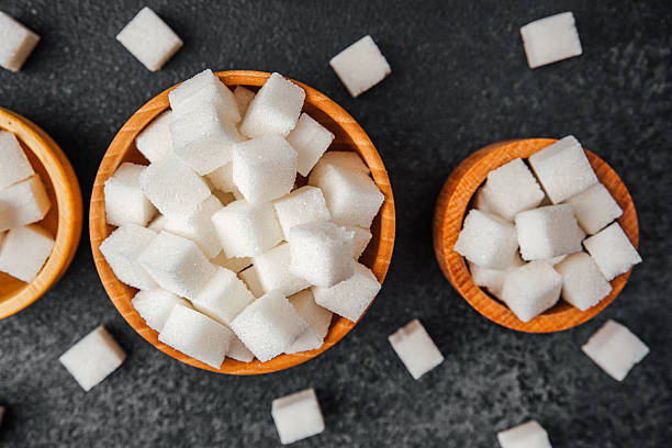 istock Sugar cubes in wooden bowls displayed on a dark surface 2221967109