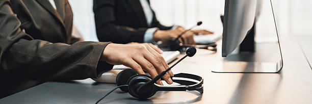 istock Panorama focus headset on call center workspace desk with blur operator. Prodigy 2221967155