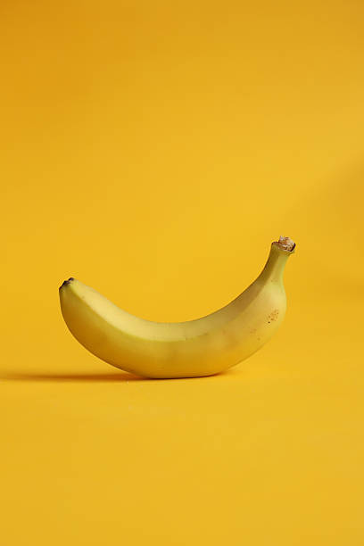 istock Image of a banana on a yellow background. 2221978537