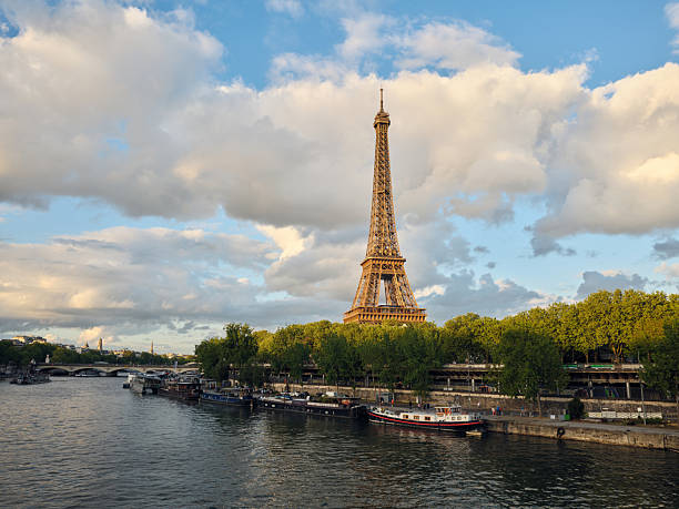 Eiffel tower rising above seine river in paris with dramatic clouds in Paris, Île-de-France, France
