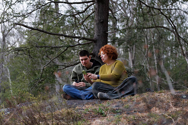 istock Poconos wilderness exploration. Redhead mother helps autistic son identify birds using smartphone in Pennsylvania forest. 2221987328