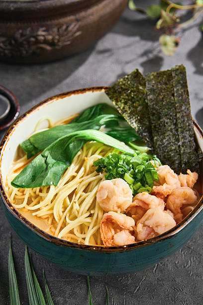Seafood ramen in bright natural lighting, closeup composition with visible nori and fresh greens