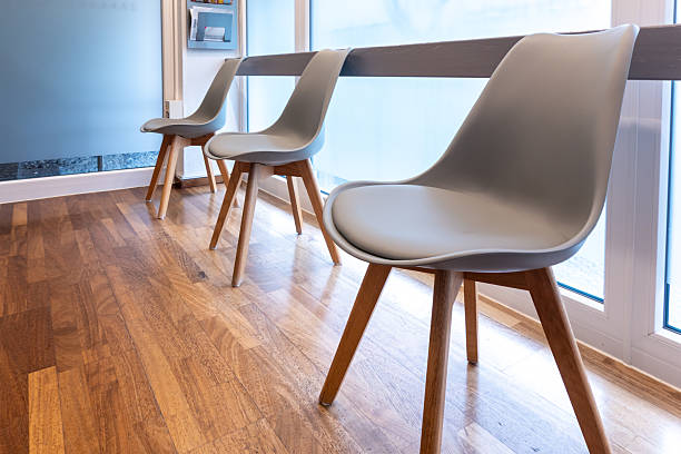 istock Modern gray chairs in waiting room by window with parquet floor 2221991437