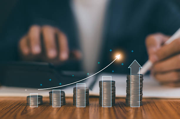 istock Businessman using calculator and financial planning with growing coin stack and digital arrow graph showing profit and business success. Concept of investment, saving, management and economic growth. 2221992817