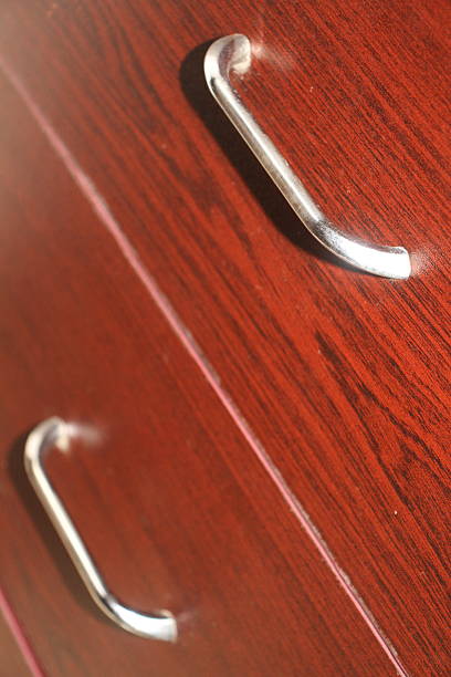 istock Shiny silver handles on a polished wooden drawer. 2221994901