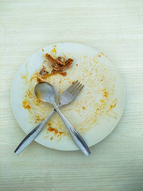 istock Empty Plate After Delicious Meal with Chicken Bones and Utensils 2221996024