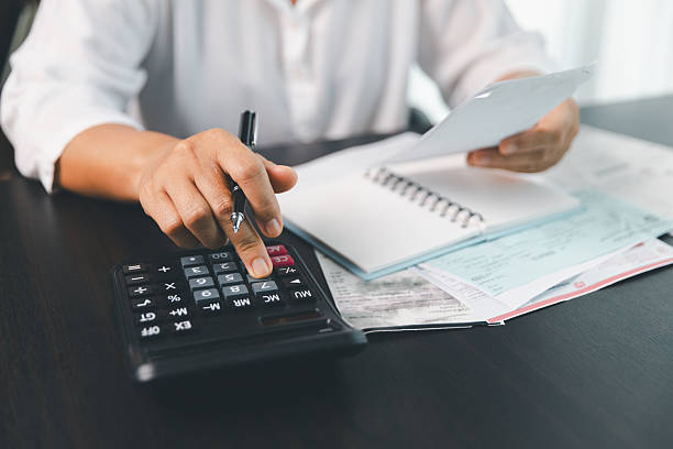 istock Using calculating machine, household carefully manages each bill and expense to plan financial budget, ensuring timely payment, consistent saving, smart investment for secure home finance strategy. 2221998876