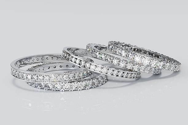 istock Five eternity rings with tiny diamonds laying on white glossy background 2222001770