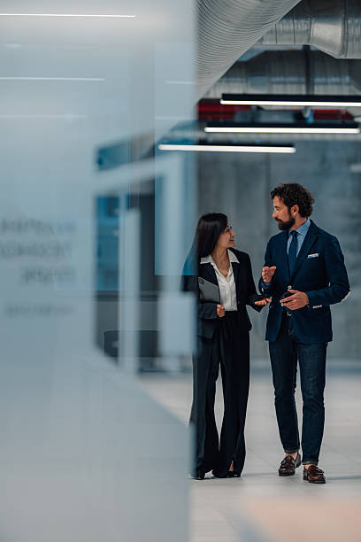 istock Businesspeople walking and talking in modern office corridor 2222006561