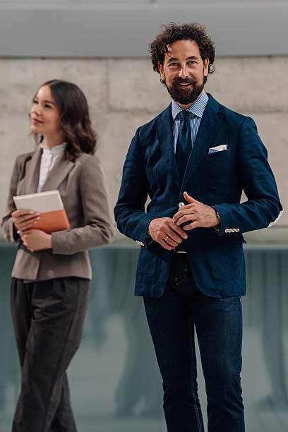 istock Businessman smiling while businesswoman holds notebook 2222006576