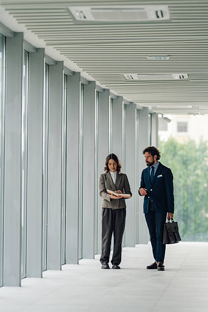 istock Businesspeople discussing work in modern office hallway 2222006656