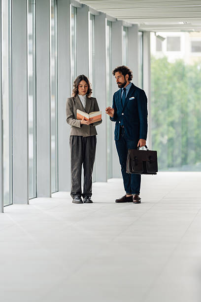 istock Businesspeople discussing book in modern office corridor 2222006660