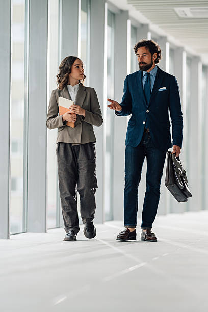 istock Businesspeople walking and talking in a modern office hallway 2222006663