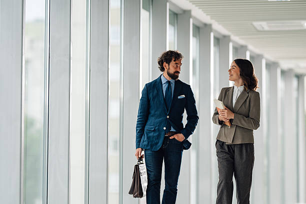istock Businesspeople walking and talking in modern office hallway 2222006664