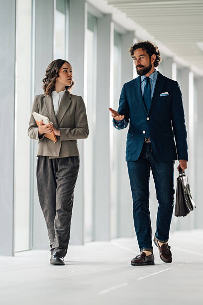 istock Businesspeople walking and talking in office corridor 2222006667