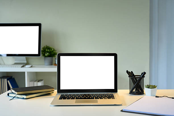istock Clean office desk featuring a laptop with a white screen, notebooks, pens, and a potted plant. 2222006724