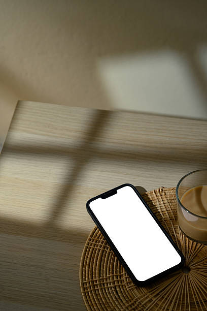 istock Smartphone with blank white screen on a round rattan coaster in warm natural light 2222006828